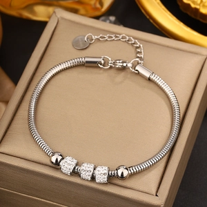 Close-up of silver snake chain bracelet featuring pavé zircon barrels and lobster clasp
