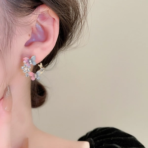 Detailed view of C-shaped hoop earring with gradient butterfly and sparkling rhinestones