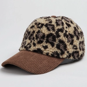 Detailed view of leopard print faux fur crown and brown corduroy brim on baseball cap
