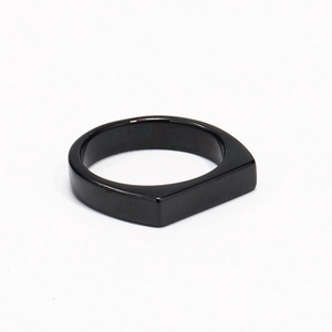 Close-up of minimalist black titanium steel ring with polished geometric facets