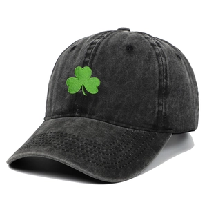 Detail shot of green clover embroidery on a vintage washed black cotton baseball cap