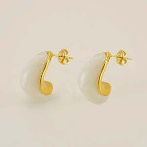 Détail de boucles d'oreilles ovales plaquées or 18 carats avec résine marbre blanc et fermoir
