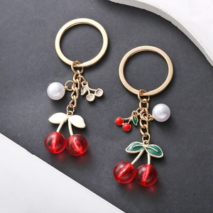 Charming red cherry keychains with elegant white pearls and golden metallic leaf accents