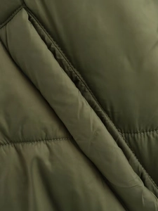 Detailansicht der gesteppten Nylonoberfläche und Taschenklappe in Militärgrün