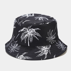 Dettaglio ravvicinato di un cappello da pescatore nero con stampe di palme bianche