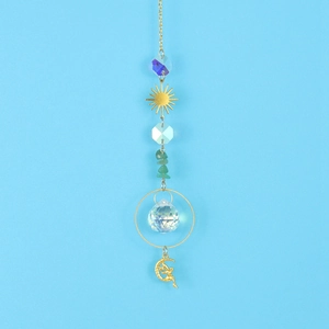 Detailed view of crystal suncatcher with golden sun moon charms and green gemstones