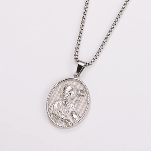 Macro detail of silver oval pendant with religious relief on stainless steel necklace