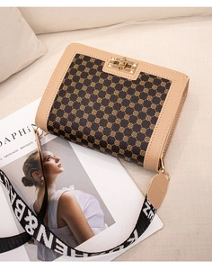 Detail view of the brown quatrefoil print crossbody bag with gold-tone metal twist lock