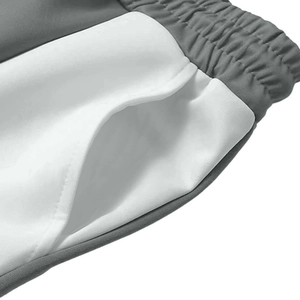 Dettaglio della coulisse in vita e delle tasche laterali dei pantaloni jogger bicolore