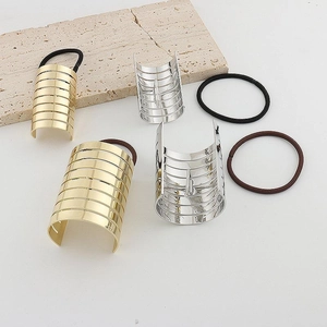 Sleek gold and silver metallic striped ponytail cuffs set on marble surface