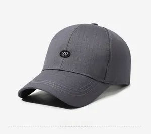 Detail of dark grey baseball cap showing SP embroidered badge and stitching craft
