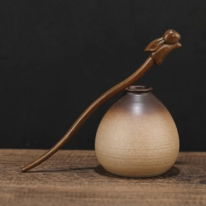 Detail of hand-carved sandalwood hair pin featuring a delicate rabbit motif on dark wood