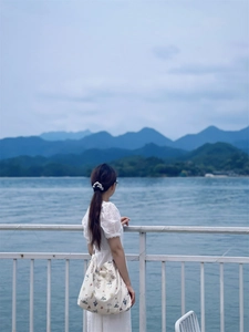 Floral print cotton tote bag shown in an outdoor scenic view by a blue lake