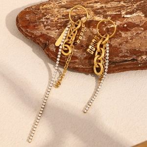 Détail macro de boucles d'oreilles pampilles dorées avec chaîne et franges en zircon