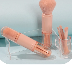 Close-up of pink portable 4-in-1 makeup brush set with clear storage tube and lid