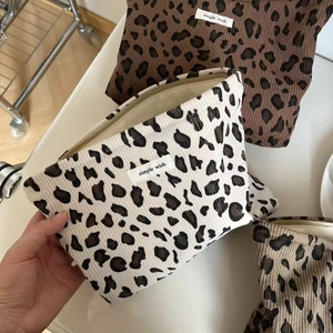Détail des trousses de maquillage en velours côtelé avec imprimé léopard et zip