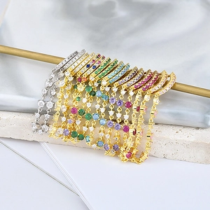 Elegant gold and silver link earrings with colorful zirconia hanging on a golden display