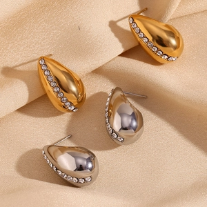 Detailed view of teardrop earrings in gold and silver finish with pavé set crystals