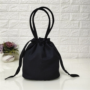 Detail view of the black canvas drawstring bucket bag with durable long handles