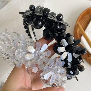 Detailed close-up of beaded floral headbands with crystals and pearls in black and clear