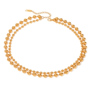 Detailed view of gold double-layer beaded necklace with lobster clasp and extension chain