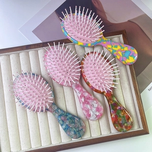 Travel-sized mini air cushion hair brushes with cute floral acetate patterns and soft bristles