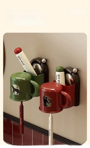 Wall-mounted bathroom organizer with artful mugs and happy day toothbrushes