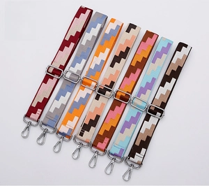 Collection of various adjustable colorful geometric patterned bag straps with silver buckles