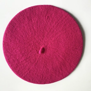Overhead view of a vibrant magenta cashmere-style beret with a top stem detail