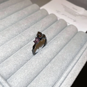 Macro shot of a black cat ring with a purple gemstone in a velvet jewelry box
