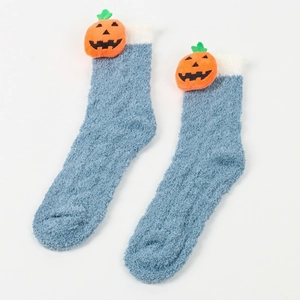 Nahaufnahme der blauen Plüschsocken mit Kürbisdekor für gemütliche Wintertage zu Hause