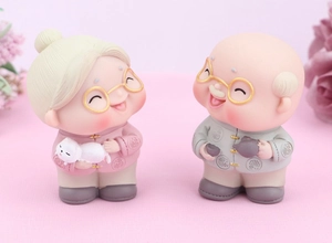Detailed view of elderly couple cake toppers with intricate resin texture and soft colors