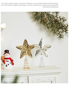 Detail of gold and silver hollow star tree topper with spiral metal base on a white surface