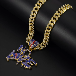 Detail of gold Cuban chain with blue zircon NO LOVE pendant and broken heart design
