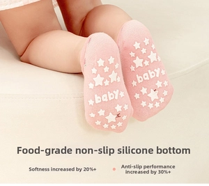 Close-up of pink baby socks with white star-shaped non-slip silicone grips on the sole