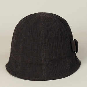 Close-up of a linen bucket hat in dark brown with textured weave and side buckle detail