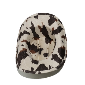 Top view of a western cowboy hat with black, white, and brown cow print pattern