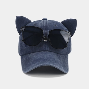 Close-up of vintage navy blue denim baseball cap with cat ears and integrated goggles