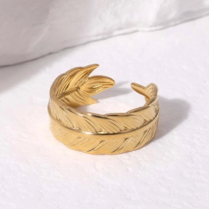 Dettaglio anello a piuma dorata con finitura lucida a specchio e design aperto