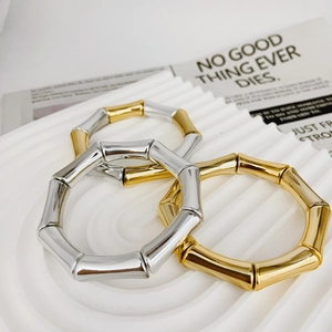 Minimalist bamboo style metal bracelets set in gold and silver finish on display