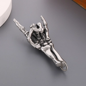 Detailed close-up of dark rock gothic skull hand pendant made of polished stainless steel