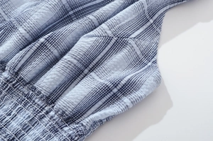 Detail of blue and white checkered smocked fabric with textured seersucker finish