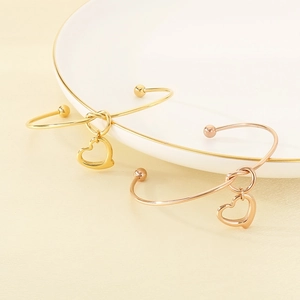 Cut-out heart-shaped open cuff bangle in 18K gold and rose gold stainless steel plating
