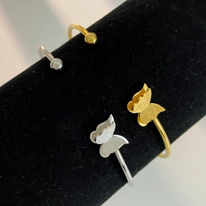 Adjustable butterfly open bangle in gold and silver finish with matte textured wings