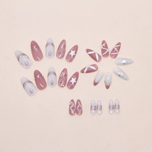 Macro detail of press-on nails with 3D pearls, star patterns and pink ribbon designs