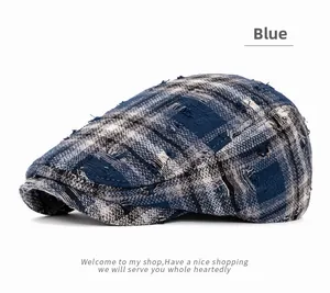 Détail de casquette plate à carreaux bleus montrant la texture sergée et l'effet usé