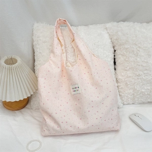 Détail du motif lapin floral et de l'étiquette zakka sur un grand sac cabas en toile rose