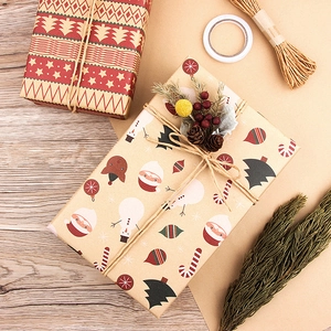 Vintage Christmas kraft wrapping paper set with Santa and snowman patterns on wood desk