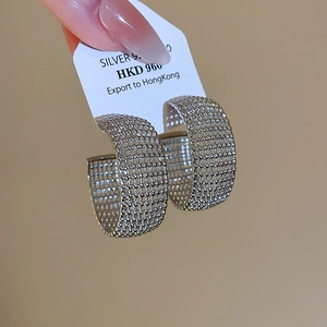 Detailed macro view of S925 sterling silver hollow mesh C-shaped hoop earrings