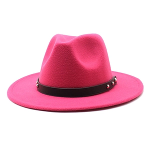 Macro detail of rose red wool fedora hat with black rivet-studded leather band